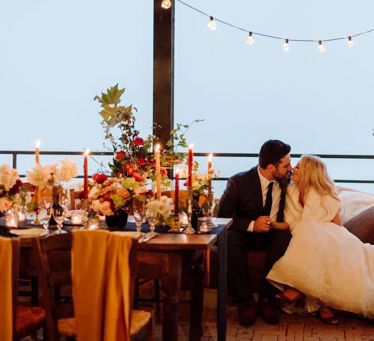 The bride and groom share a kiss at their reception dinner for their elopement in Italy