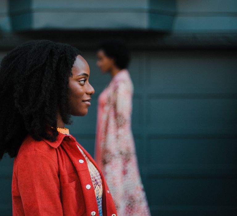 Black bride-to-be with afro hair in a burnt orange suede jacket at engagement session