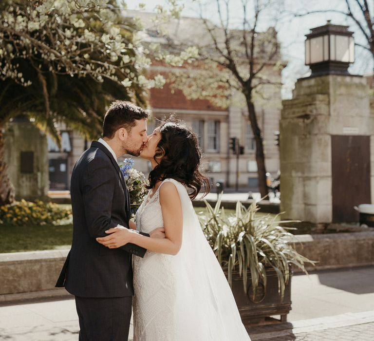 Bride and groom share a kiss outside Hackney Town Hall