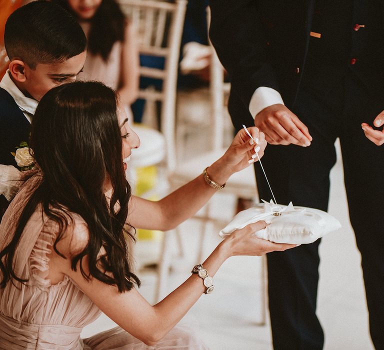 Bridesmaids and page boy removing the wedding rings from a cushion at Brent Civic Centre wedding ceremony 