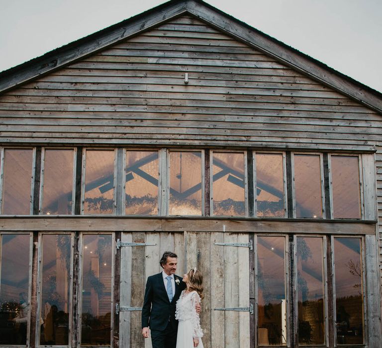 Rustic luxe wedding ideas - Bride and groom outside the wood and glass barn at High Billinghust Farm