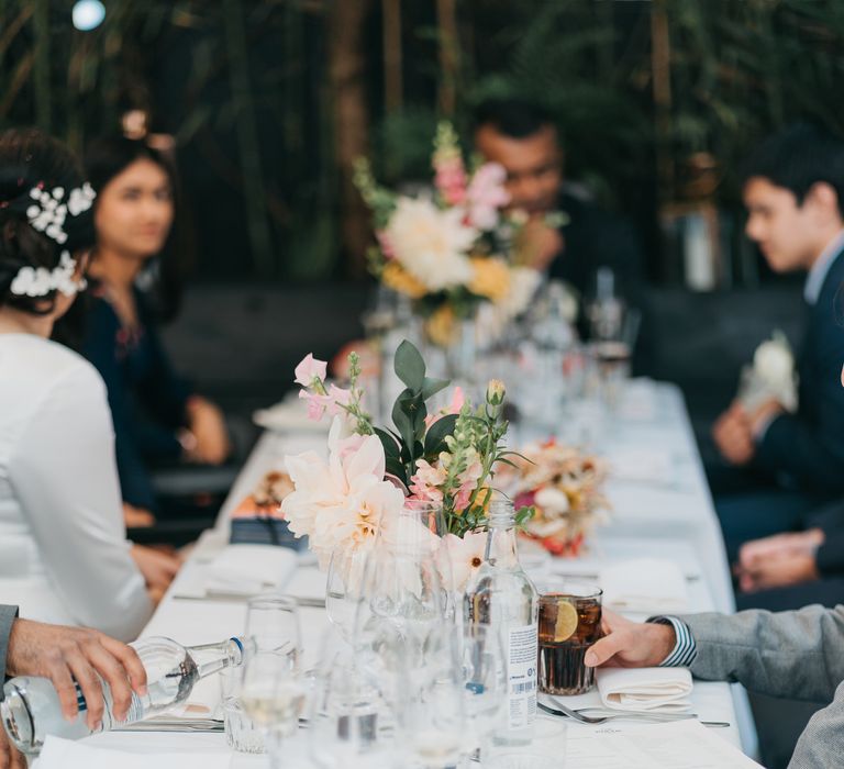 Wedding reception at The Phene with botanical vibes and white table cloth with brightly coloured florals in vases