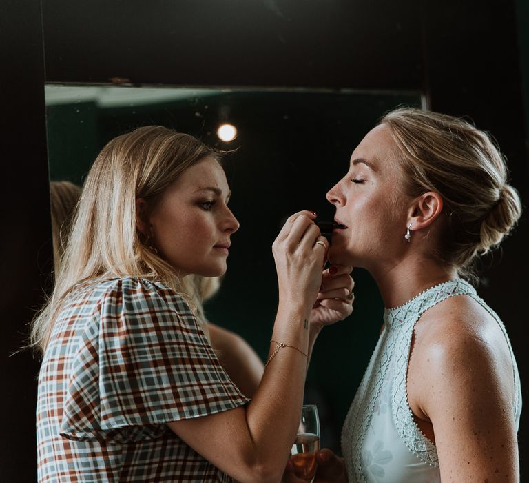 Bride has her lipstick done on the morning of her wedding day