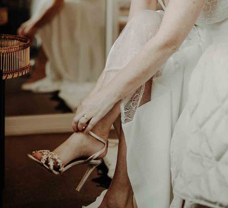 Bride puts on her metallic wedding shoes