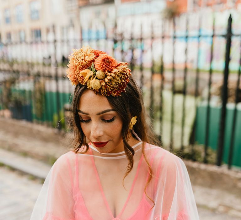 Beautiful bride in a coral wedding dress with cape veil and Frida Kahlo flower crown 