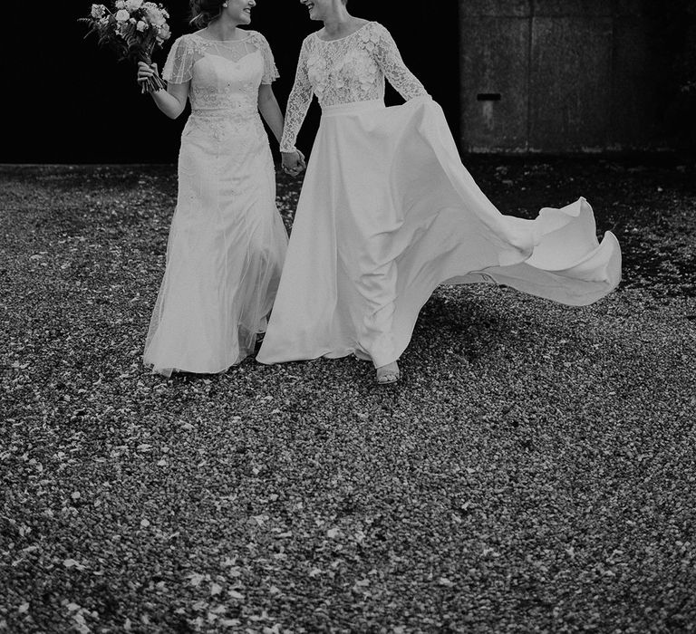 Black and white portrait of two brides in an A line embellished wedding dress and appliqué bodice with long sleeves and full skirt bridal gown 