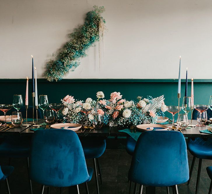 Stylish wedding reception decor with teal velvet chairs, gypsophila flower clouds and taper candles 