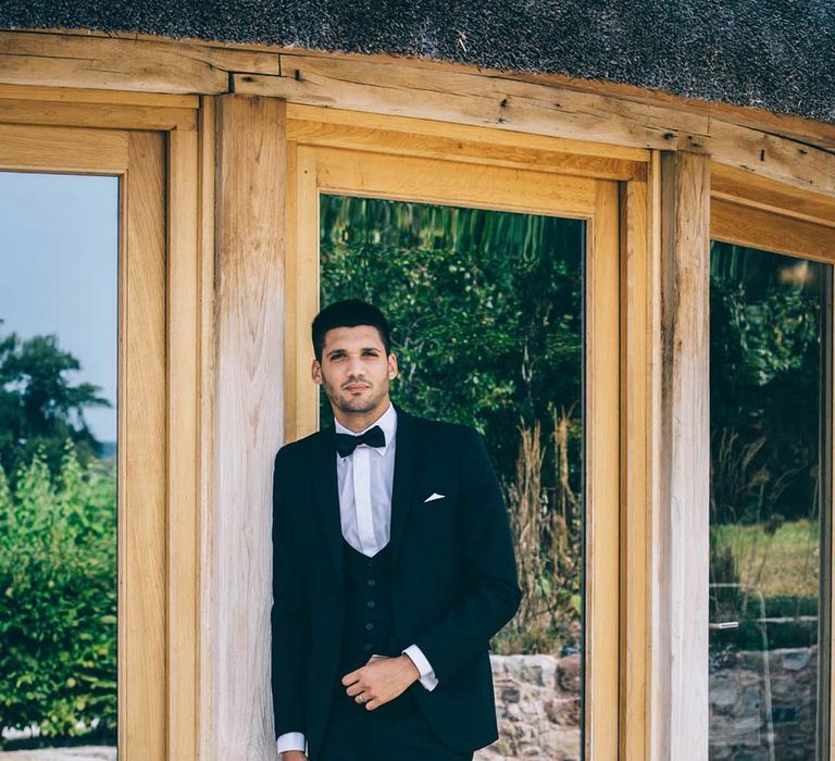 Groom in a black tie suit for boho wedding at Brickhouse Vineyard in Devon