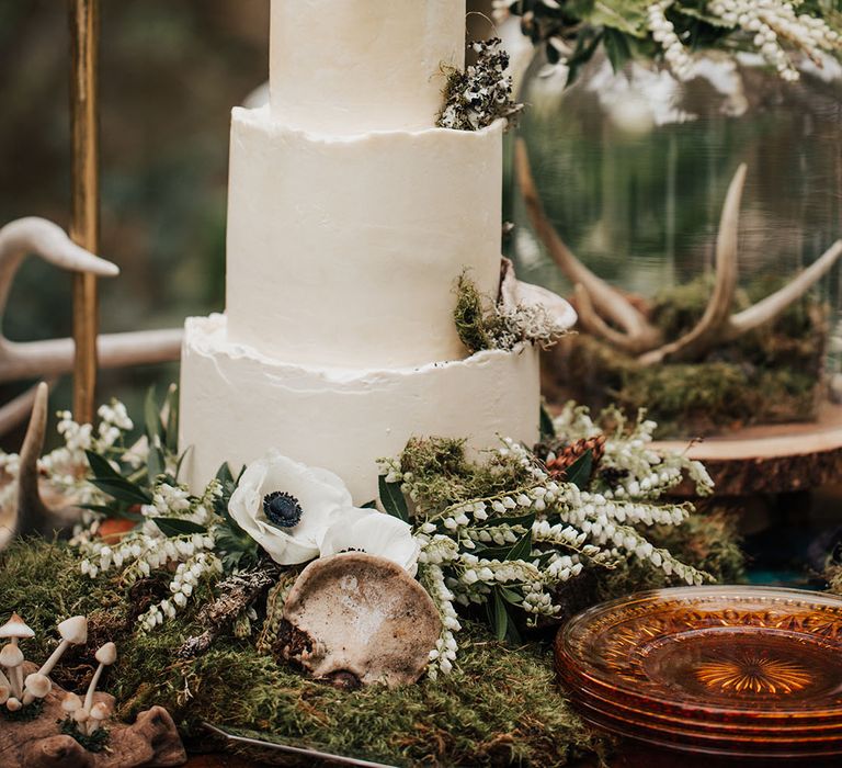 three tier buttercream wedding cake decorated in foliage, moss and anemones 