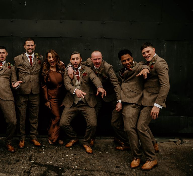 groomsmen and woman in brown beige suits and satin dress at Lyde Court autumn wedding 