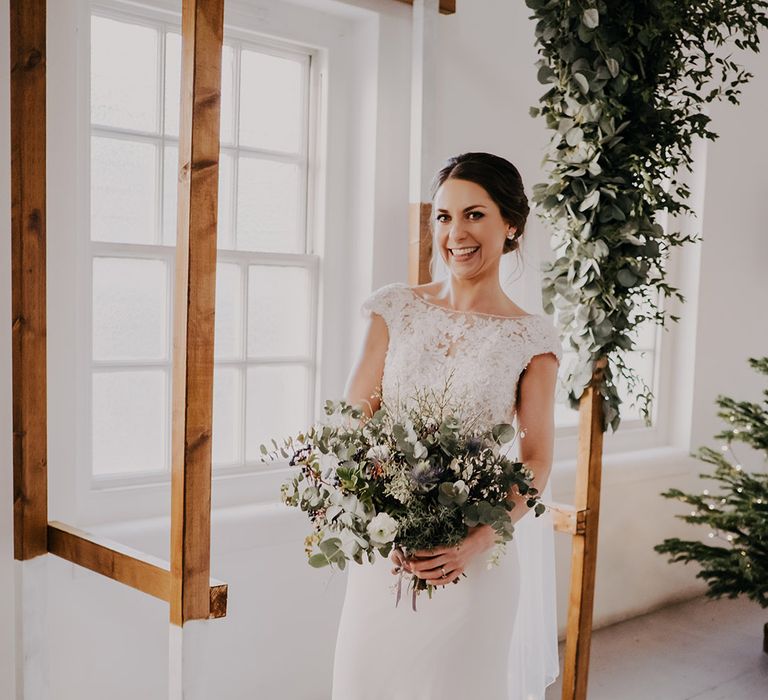 Bride holds floral bouquet on her wedding day