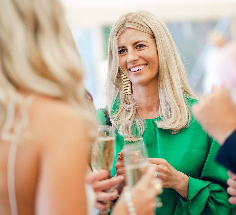 Wedding guest in green dress with gold earring