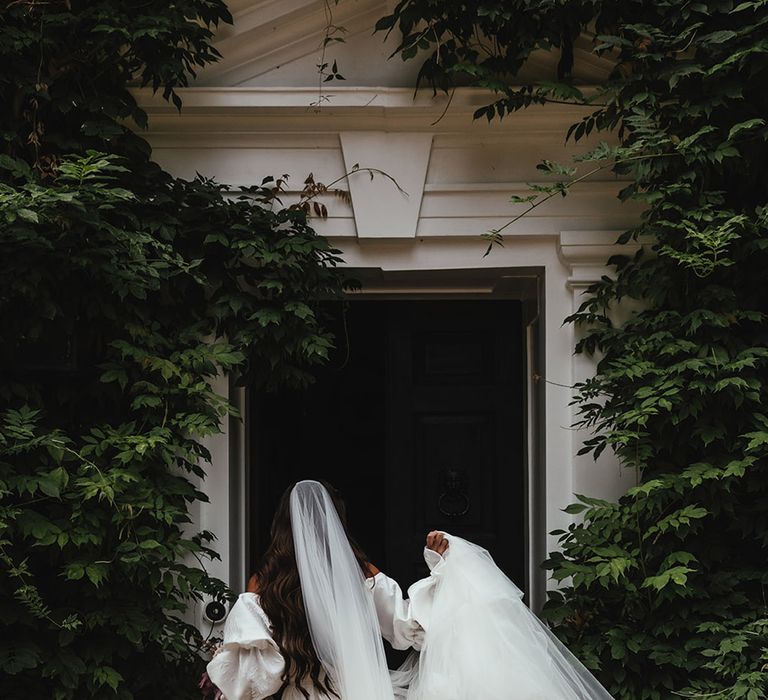 Bride in textured off the shoulder Emma Beaumont wedding dress with puff sleeves and veil 