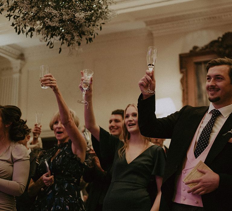 Wedding guests raising a glass at Hedsor House wedding