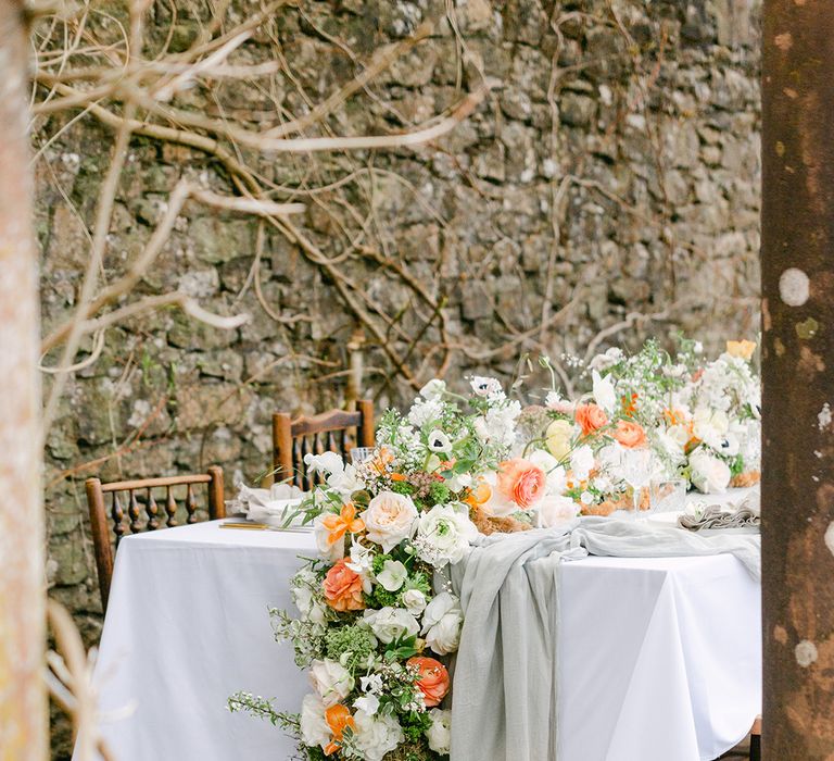 peach and white flower table runner decor at Holesfoot outdoor wedding reception table 