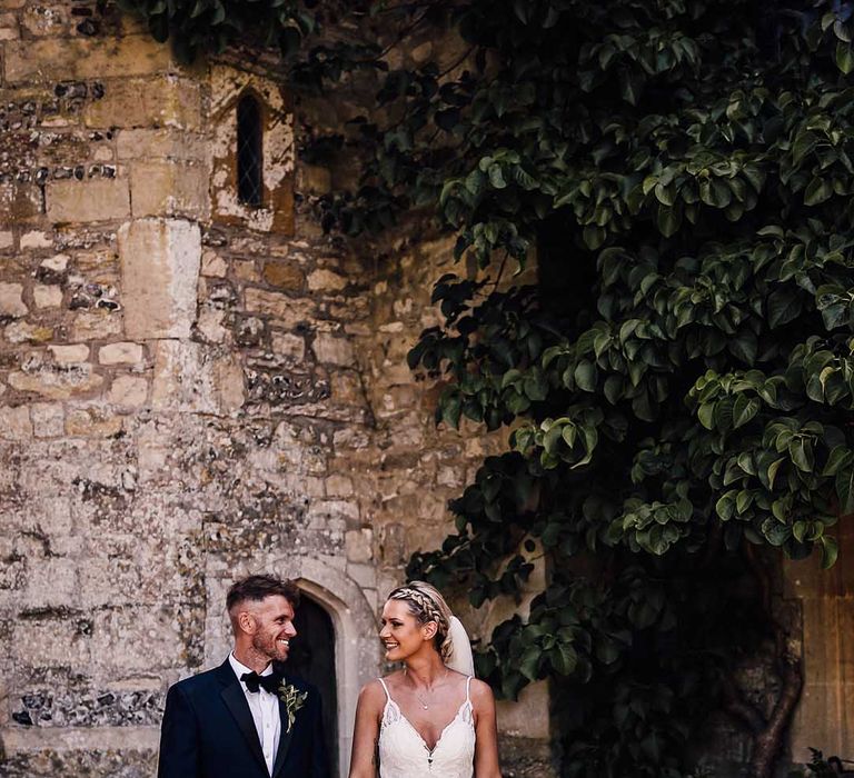 Bride and groom walk holding hands outside Athelhampton House wedding venue 