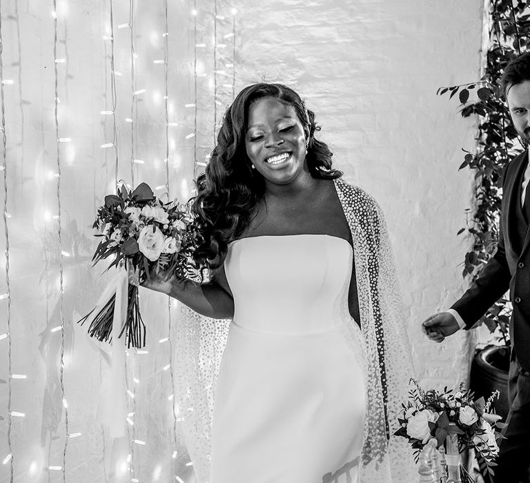 Bride wears tulle wedding cape with glitter polka dots and Suzanne Neville wedding dress 