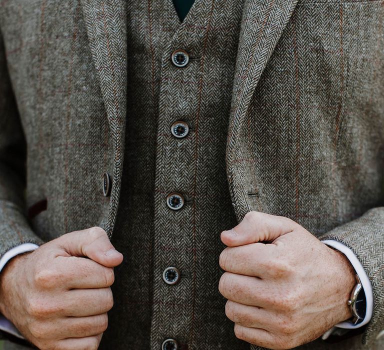 Groom wears a grey tweed three piece suit 