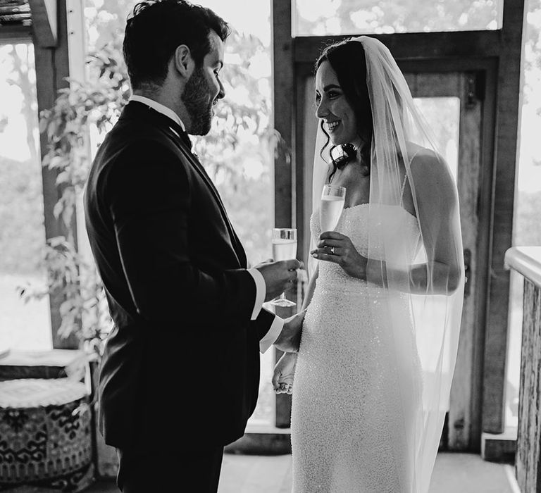 The bride and groom share a glass of champagne together to celebrate their wedding 