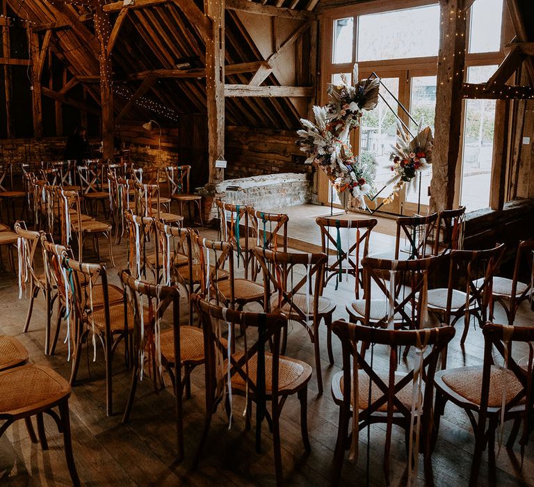 Silchester Farm rustic wedding venue with colourful ribbon chair back decor and dried flower altar decoration 