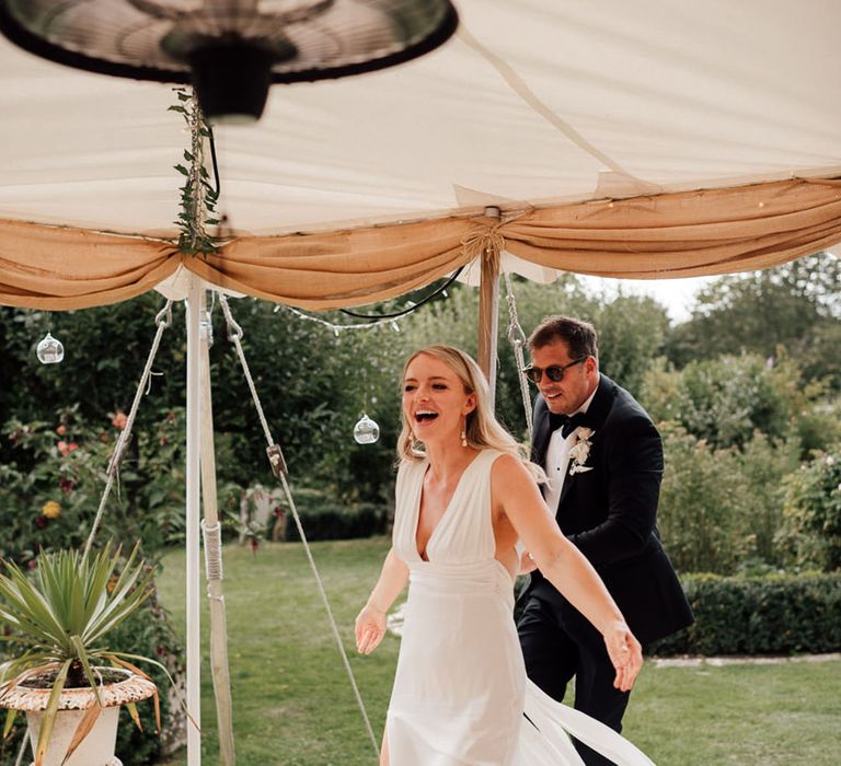 Bride and groom enter into the marquee wedding reception 