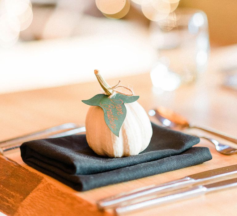 Mini pumpkin complete with place name leaf on black fabric napkin 