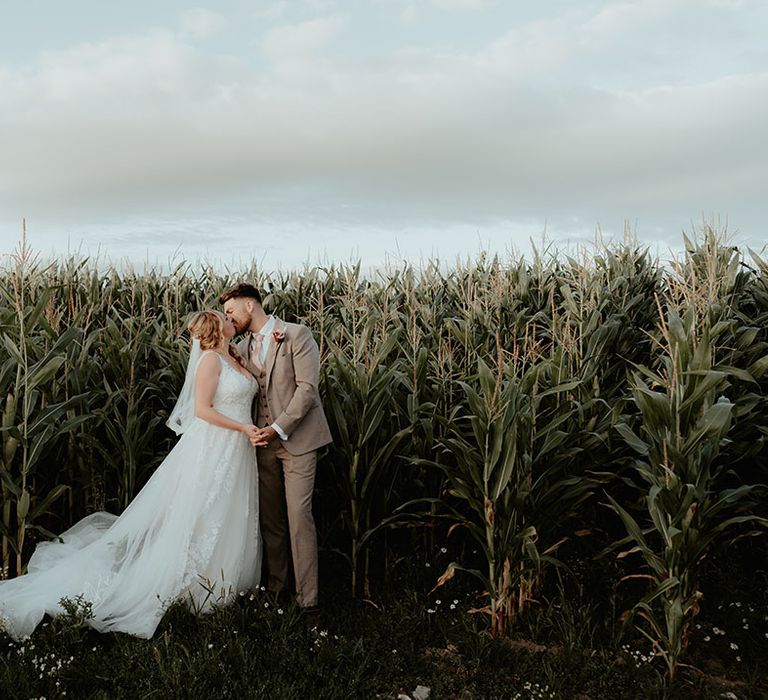 Bride & groom kiss outdoors at The Apple Orchard during festival wedding reception 