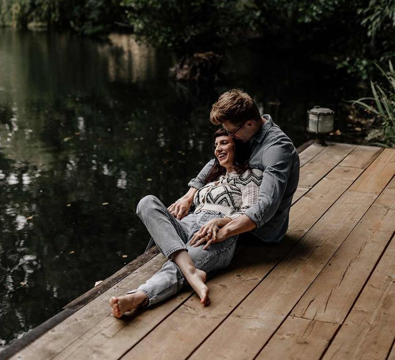 Bride and groom embracing on wooden pier next to a lake for Prezola wedding honeymoon 