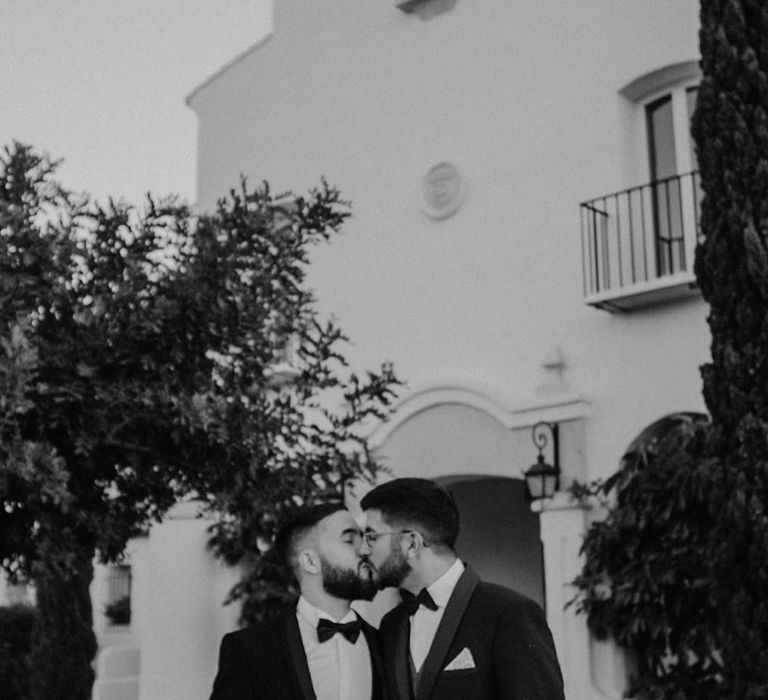 LGBTQI+ wedding with two grooms kissing in tuxedos at Hotel Cortijo Bravo, Málaga wedding venue