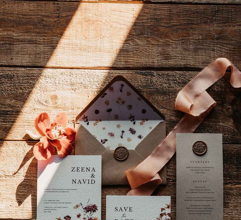 Botanical luxe wedding stationery with minimalistic tones and font, dainty floral decorations and light orange ribbon 