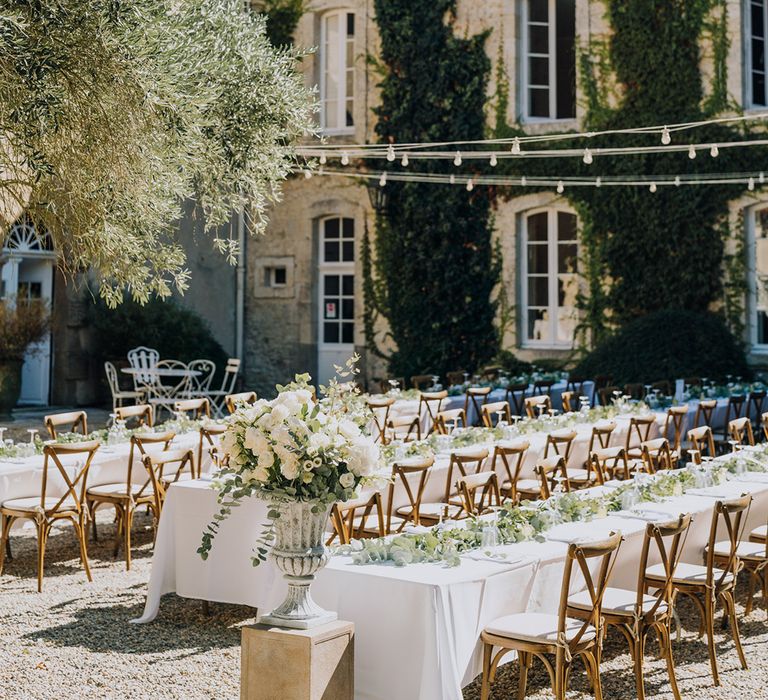 al fresco wedding reception at Château de Malliac with white flowers and festoon lights 