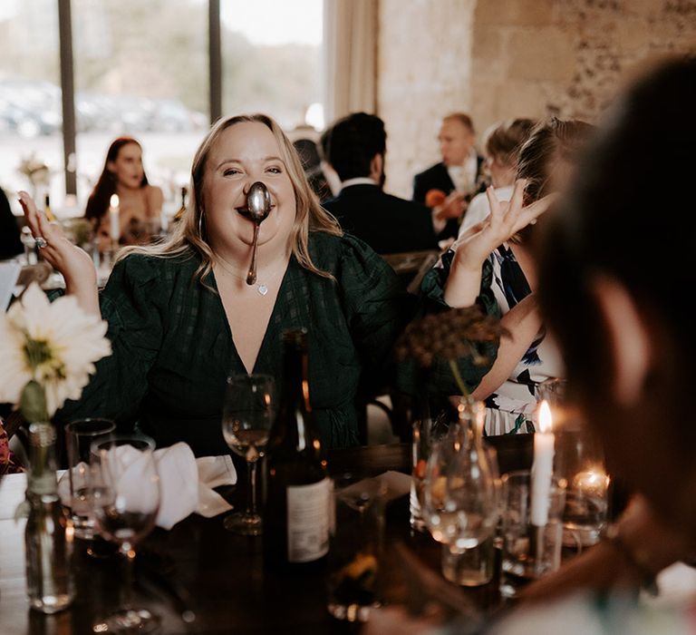 A wedding guest balances a spoon on their nose for funny wedding photo