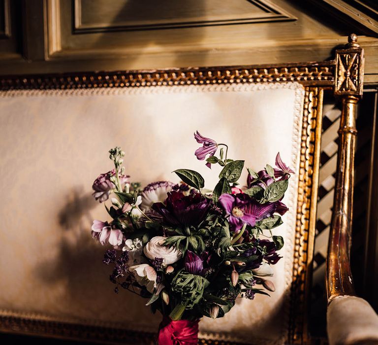 Purple and white wedding bouquet tied with dark red ribbon 