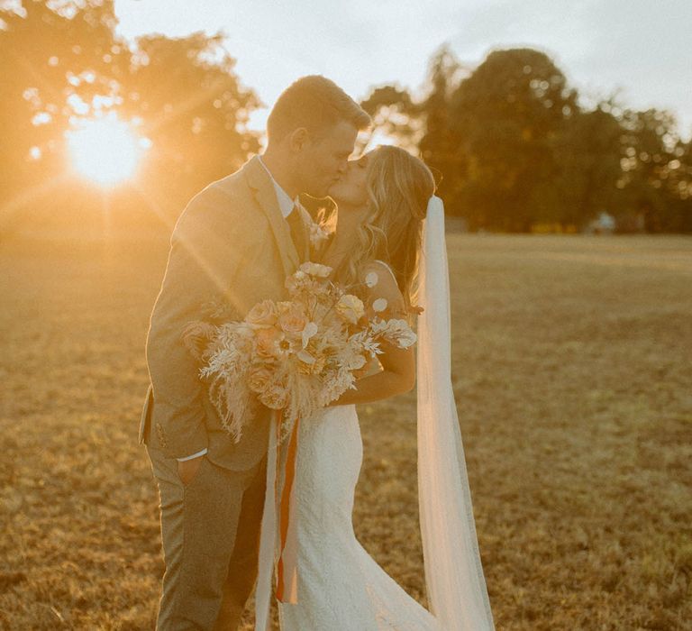 Golden hour wedding photography of the bride and groom sharing a special kiss on their wedding day in late September 