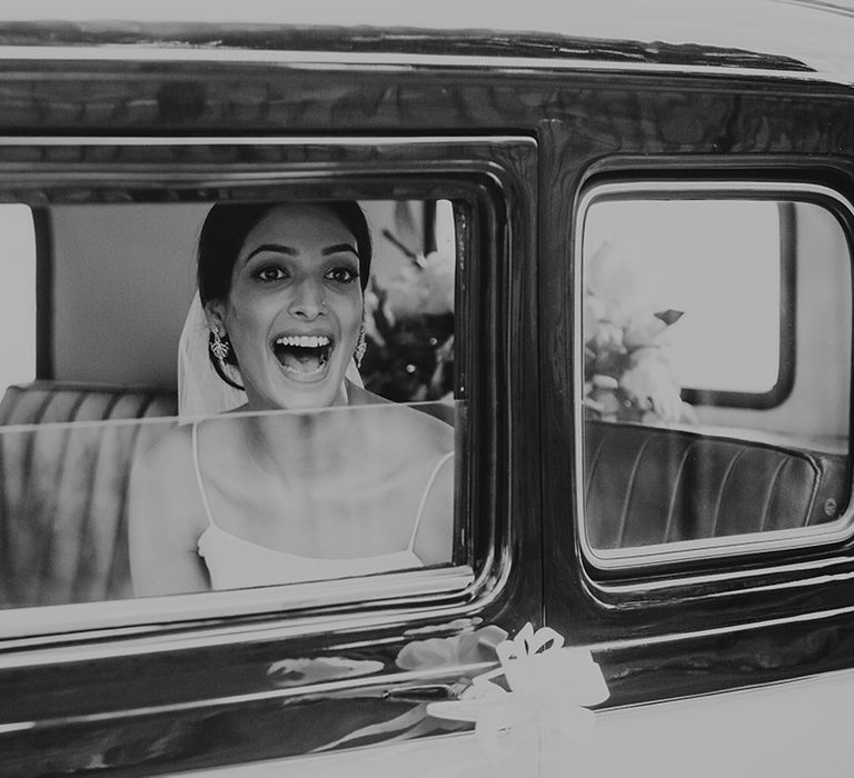 Bride in traditional wedding car on the way to the wedding 