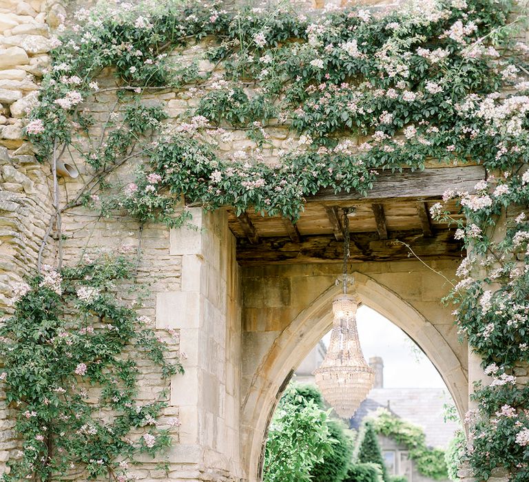 bride and groom kissing under a crystal chandelier at Euridge Manor's crumbling archway for Italian themed wedding 