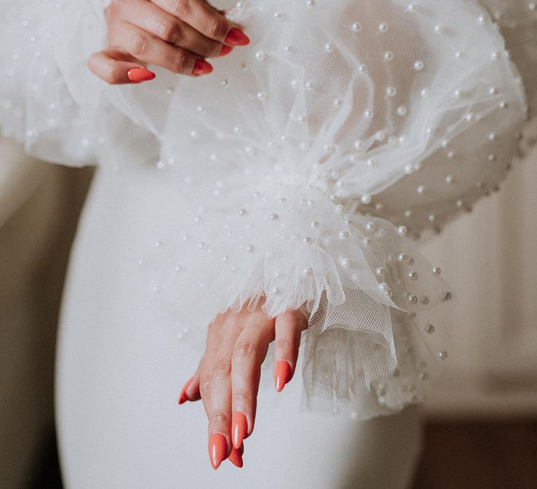 Bride wearing detachable pearl puff sleeves 