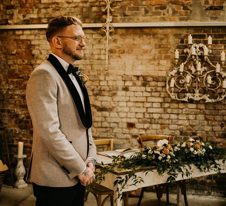 Groom in black and beige neutral wedding tuxedo for the rustic wedding at Botley Hill Barn in Surrey 