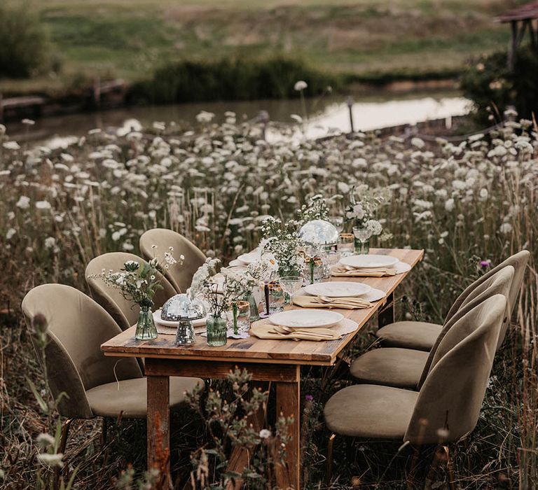 Outdoor wedding tablescape in daisy field with a green and white wedding theme 