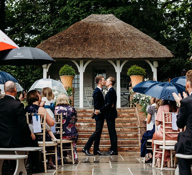 Deer Park Country House outdoor wedding ceremony with guests holding umbrellas 