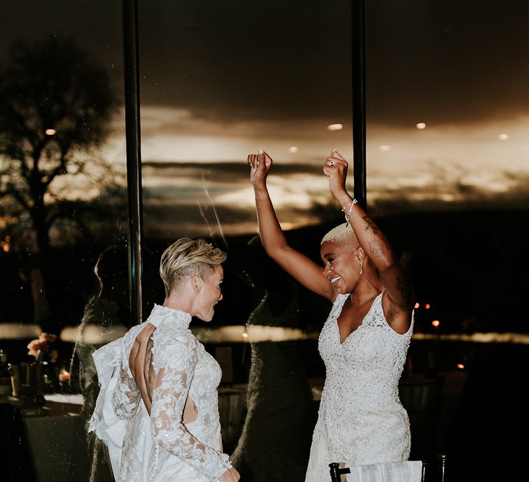 The brides dance together at their wedding reception 