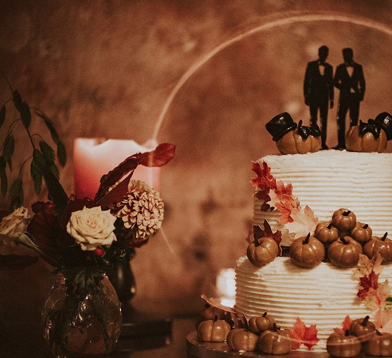 Two tier spooky wedding cake for autumnal Halloween wedding with mini pumpkins and custom cake topper 