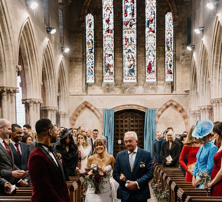 Father of the bride walks bride down the aisle at the church wedding 