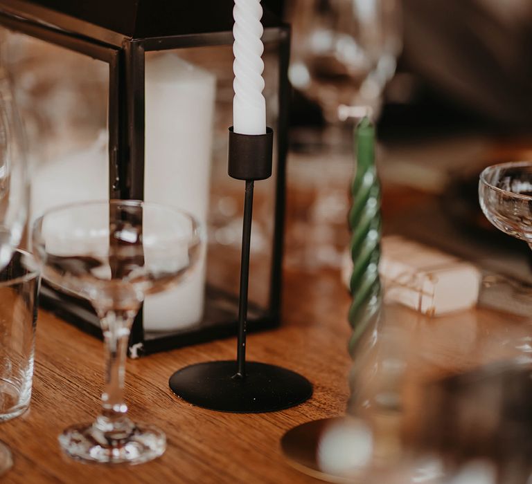 White twisted candle in black candle holder for minimalist black theme wedding tablescape 