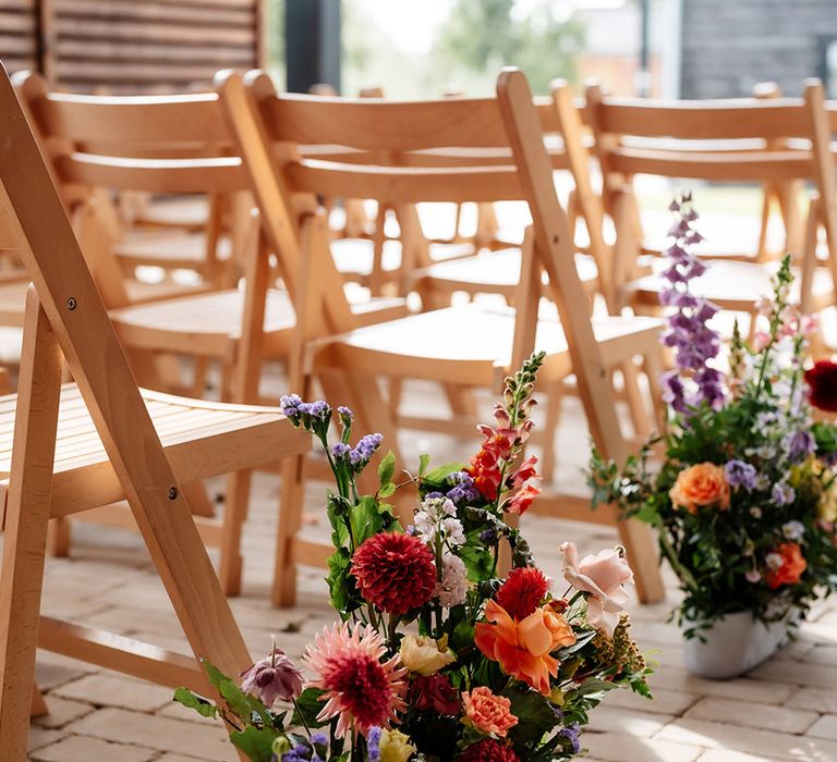 Colourful bright meadow aisle wedding flowers for natural outdoor wedding ceremony 