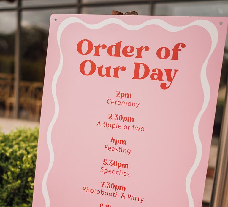 Pink order of the day wedding signage 