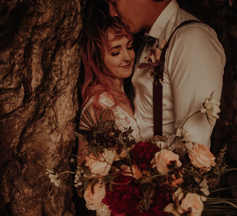 Groom kissing his brides head