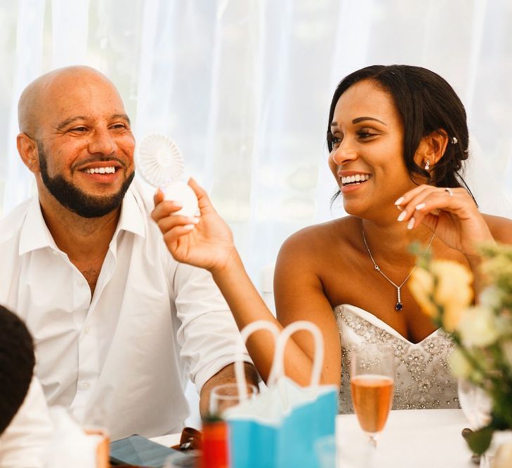 Bride cools groom down with fan at French wedding