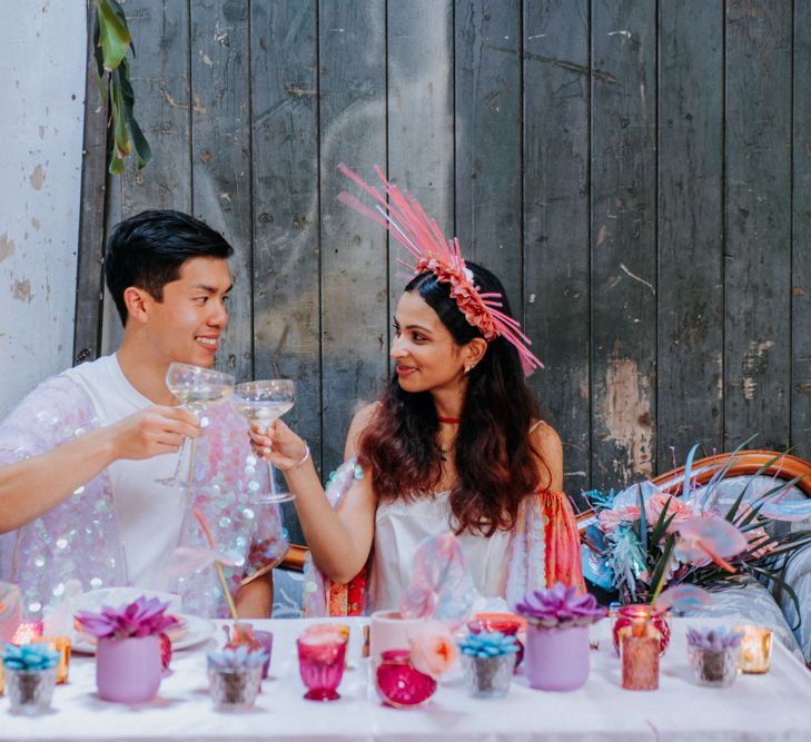 Bride and groom sipping champagne at sweetheart table 