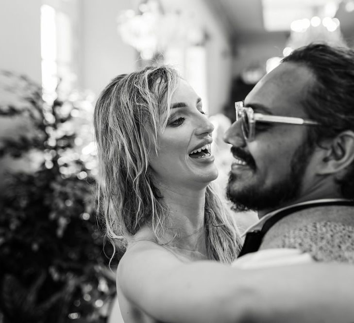 black and white portrait of bride and groom laughing 